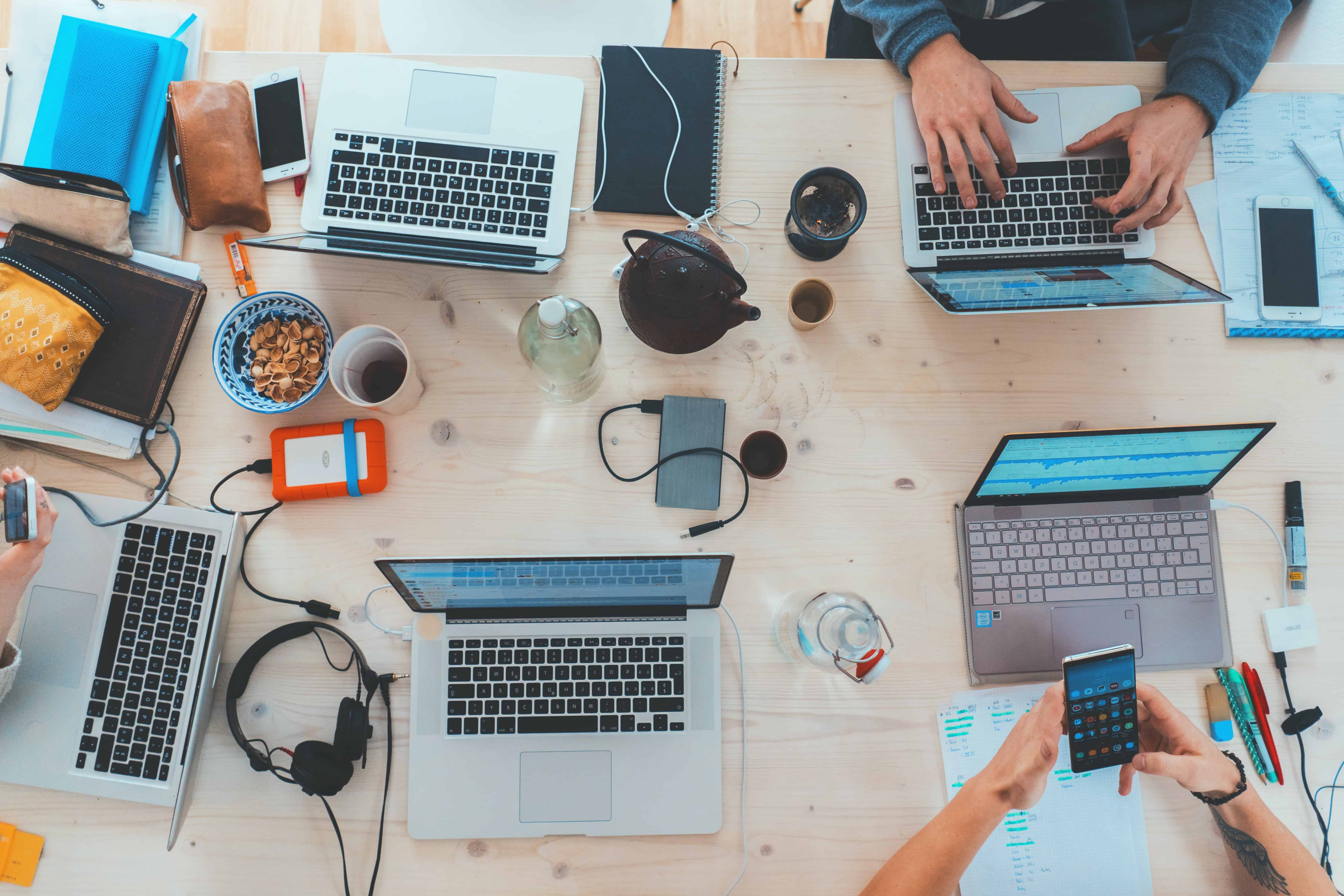 Image of employees collaborating at their laptops 